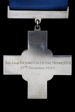 George Cross medal on blue ribbon. Front 'For Gallantry'. Back Inscribed 'Sub-Lieut RICHARD VALENTINE MOORE R.N.V.R. 27TH December, 1940'